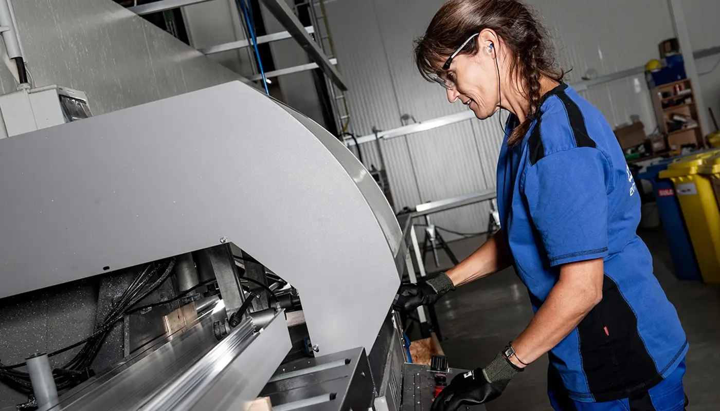 Frau in der Produktionshalle an einer Anlage